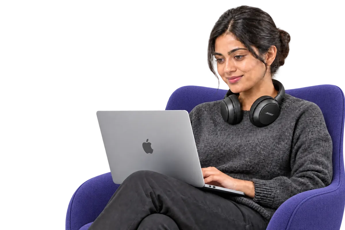 A cloud engineer working on a laptop in an armchair