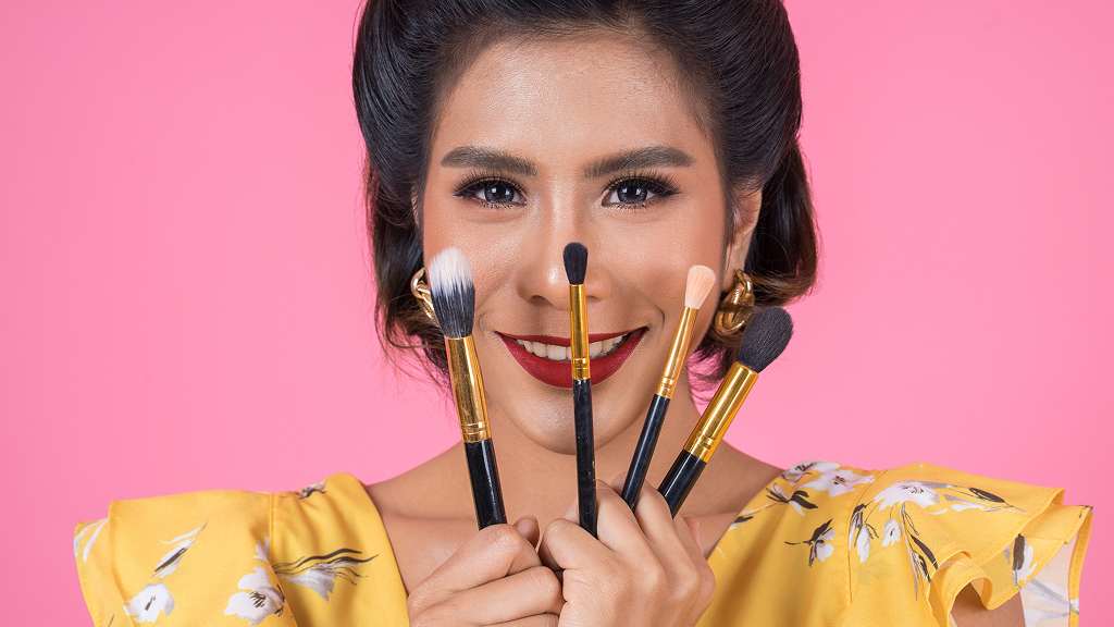 Makeup brushes on a girl’s face